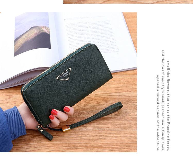 Casual single pull ladies wallet in lychee pattern PU leather with zipper and wrist strap on wooden table