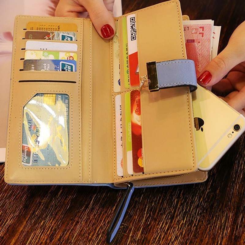 Beige women's wallet purse with multiple card slots, zipper pocket, and phone compartment on wooden table
