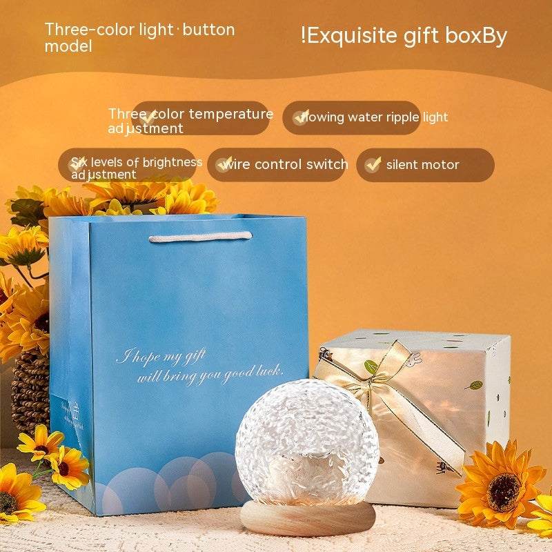 Projector small night lamp with flowing water ripple light and remote control on wooden base with gift boxes and sunflowers