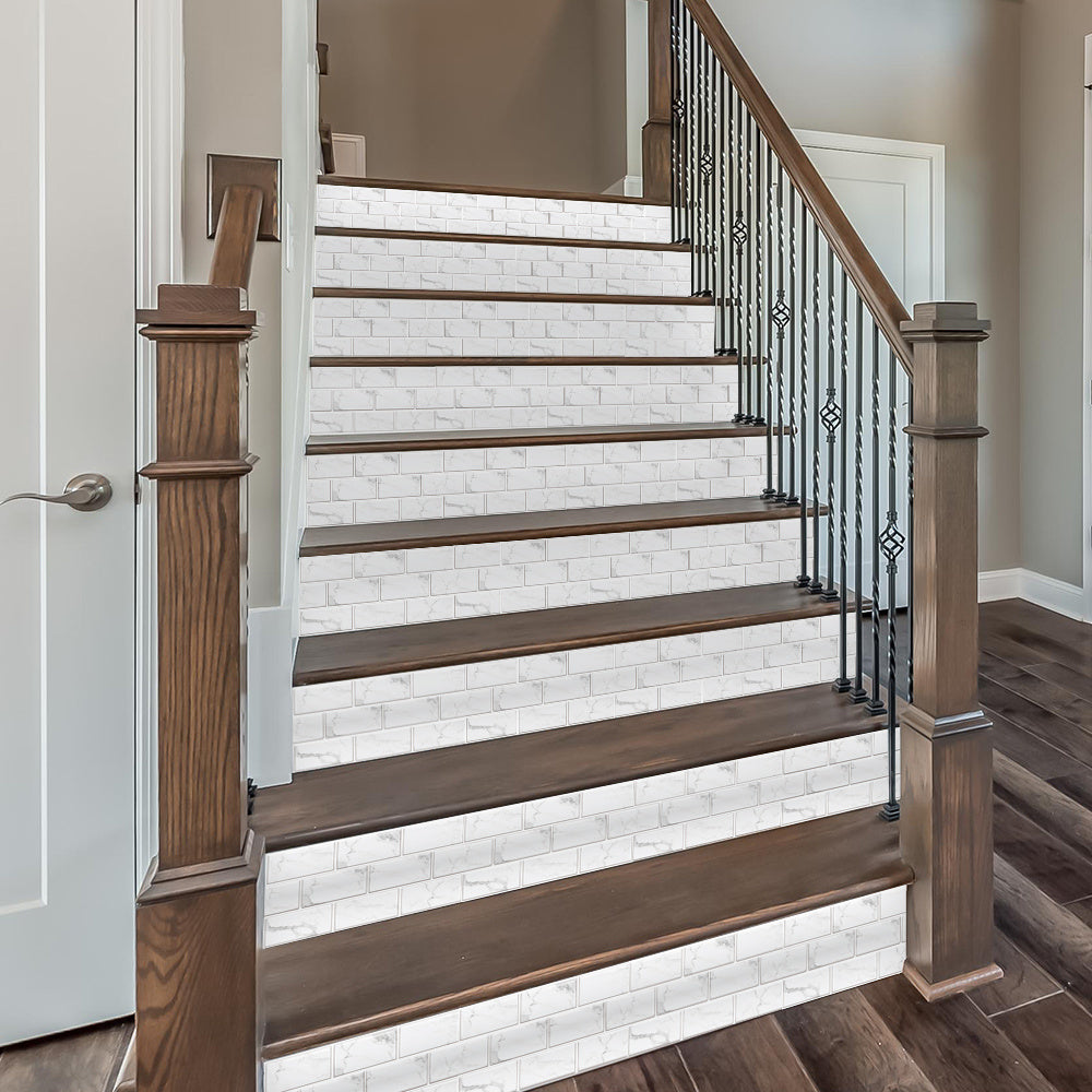 white marble look peel and stick tile stickers on stair risers with wood steps and black iron railing
