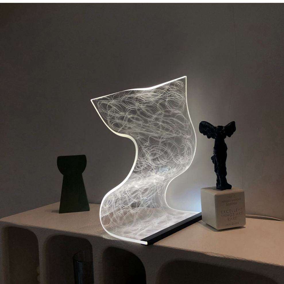warm high appearance level bedside lamp with abstract illuminated design on table