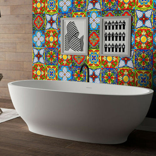 Bright laminated mosaic tile sticker with colorful geometric retro patterns on bathroom wall behind white freestanding bathtub