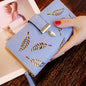 Blue wallet women purse with leaf cutout design and gold leaf charm held in hand