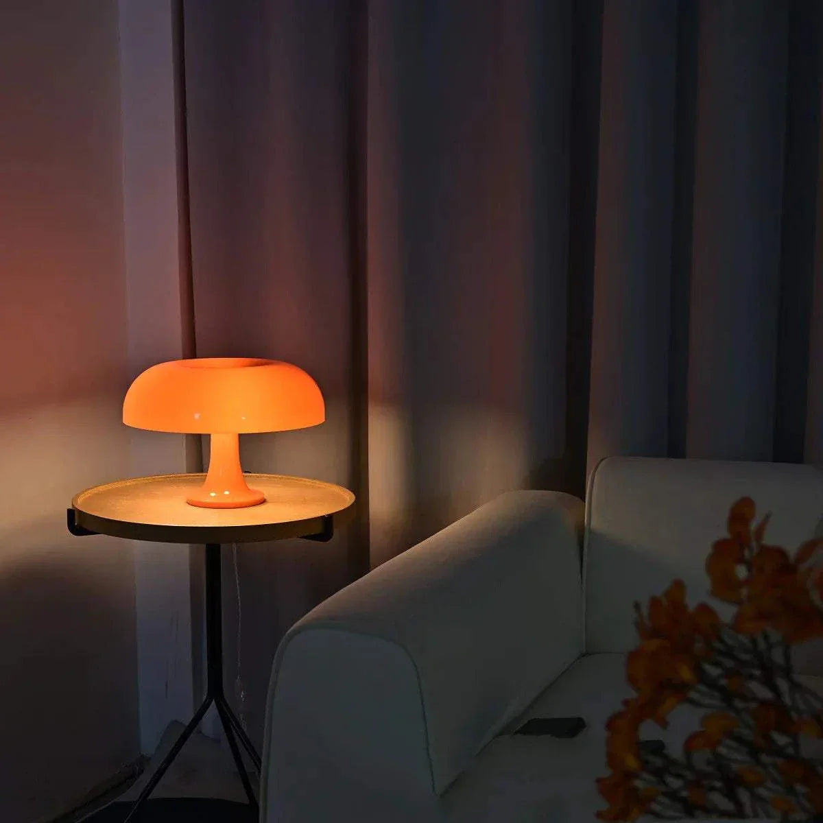 Orange mushroom table lamp with soft warm LED light on a wooden side table in a cozy living room setting