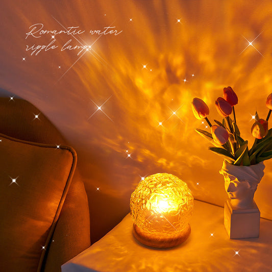Projector small night lamp creating warm water ripple effect ambient light on bedside table with flowers and couch nearby