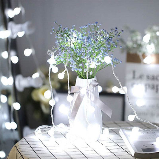 LED USB remote control string lights with small glowing balls decorating a vase with flowers on a table