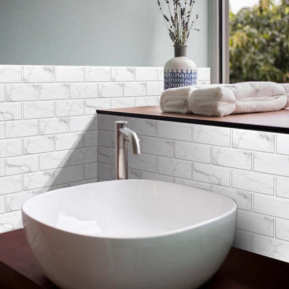 white marble look peel and stick tiles backsplash in bathroom with white vessel sink and wooden countertop